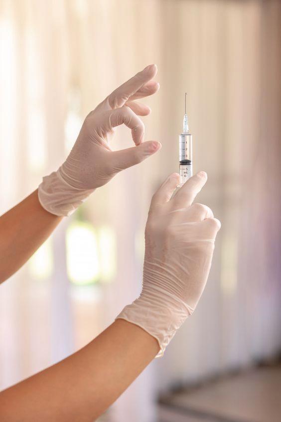 Close-up of a Vitamin D injection being administered in a clinical setting.